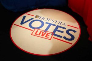 Round sign saying "Hofstra Votes LIVE"